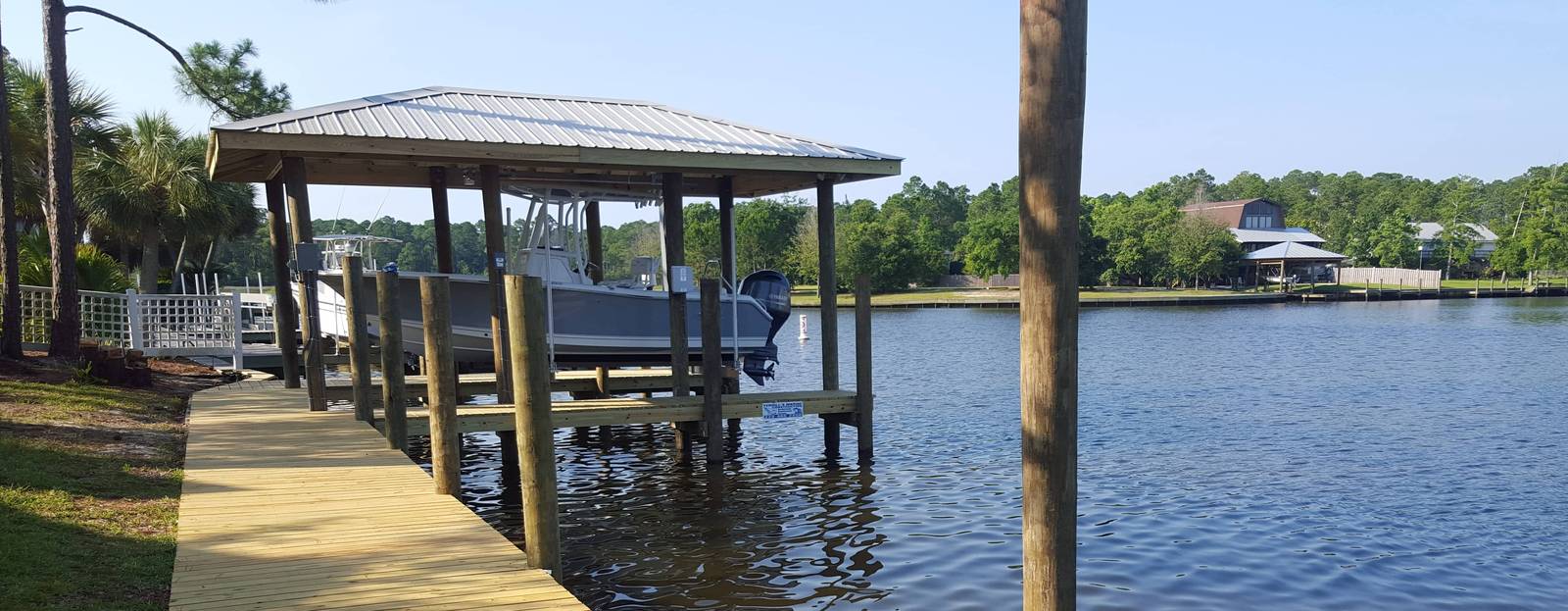 Boathouse with a boat at the end of a long dock