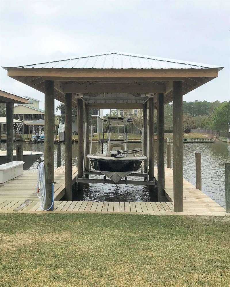 Boathouse with a boat on its lift, lawn in front