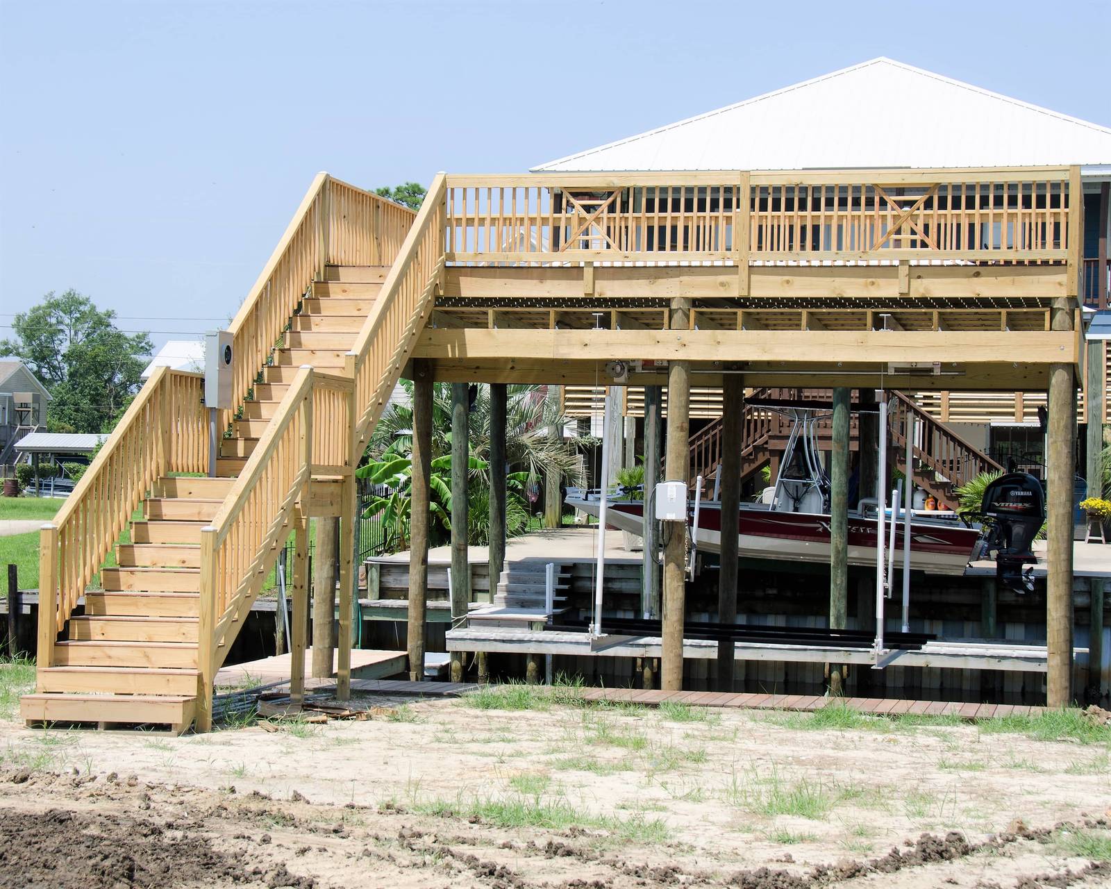 New boathouse with a sundeck on top and a wooden staircase