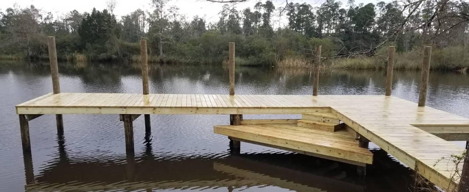 L-shaped wooden dock with steps down to the water