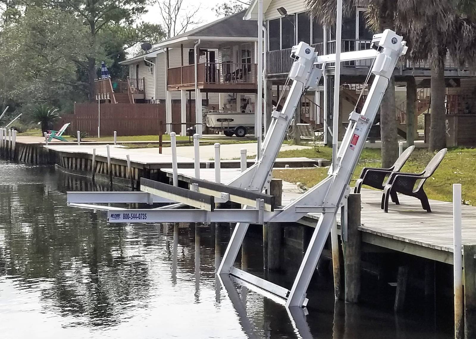 Aluminum elevator boat lift raised at a bulkhead