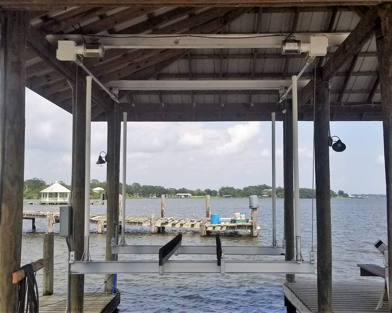 Boat lift under a boathouse looking out to the bay