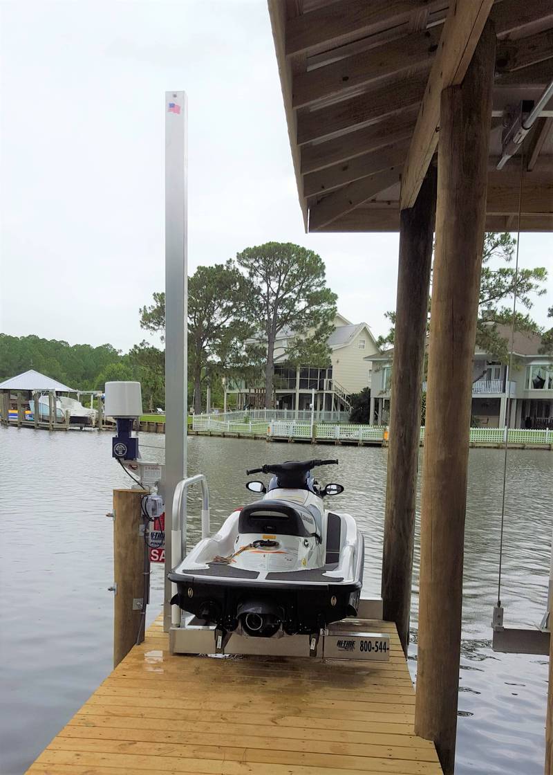 Jet ski on a spinner lift beside a boathouse